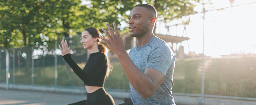 Two people exercising outside.